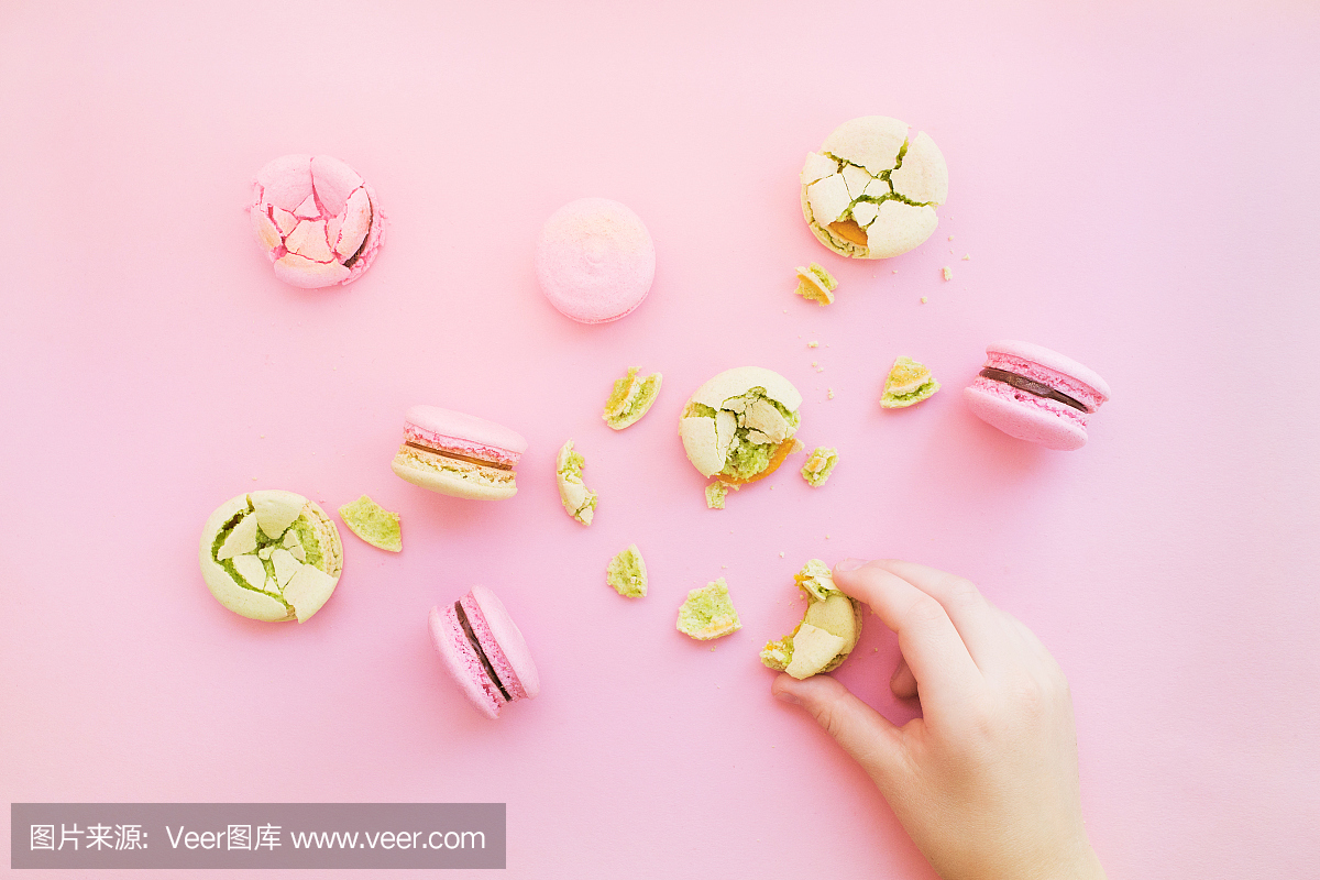 一群麦卡龙和小孩的手拿macaron。