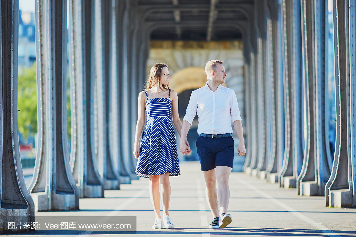 在法国巴黎沿Bir-Hakeim桥走的夫妇