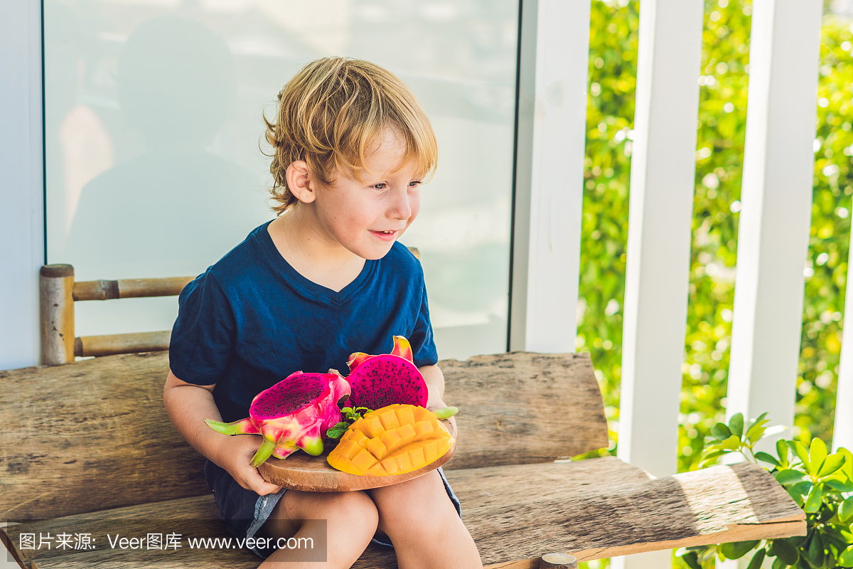 在男孩手中切丁火龙果和芒果