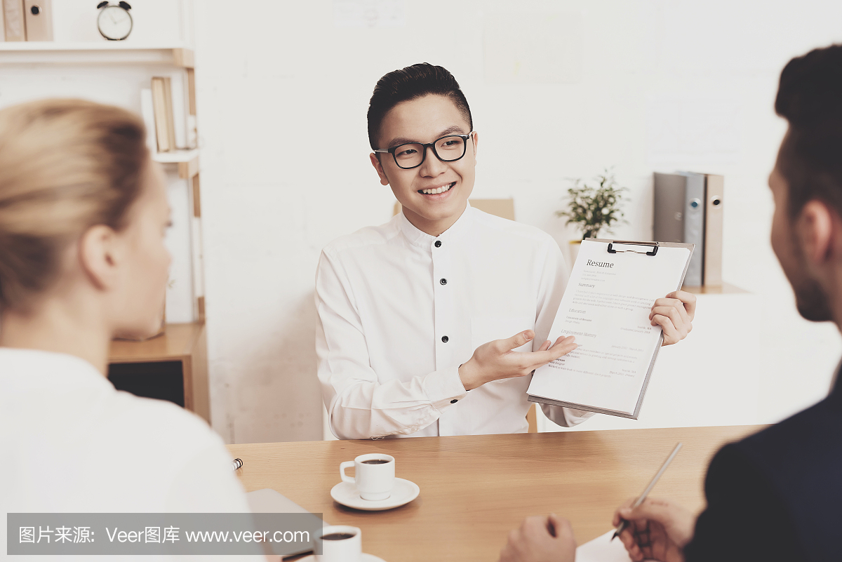 在办公室工作。工作人员正在面试时讨论简历。