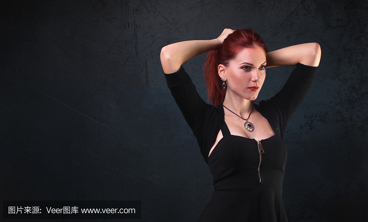 蓝眼睛的红头哥特式女孩在马尾辫拉她的头发