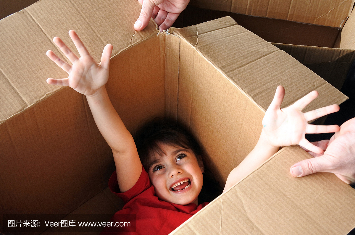 快乐的女孩在一个大的纸板箱移动到一个新的房