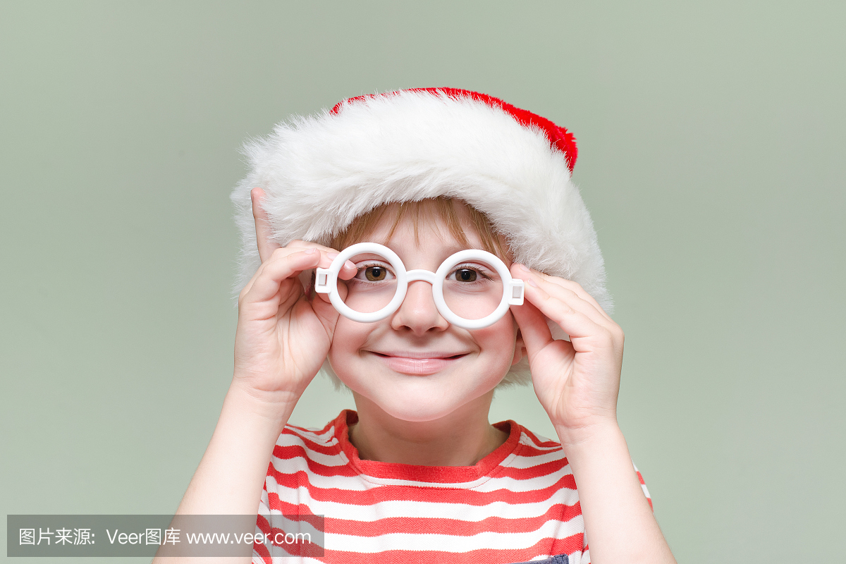 男孩戴着圣诞老人的眼镜和帽子。肖像
