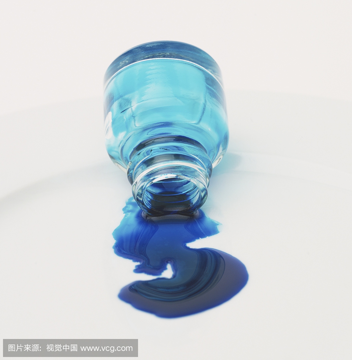 蓝色墨水从玻璃壶中倒出来,放在白板上,正视图