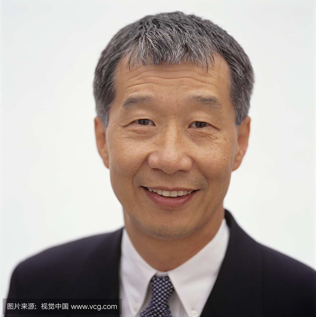 成熟的男人与短的灰色头发摆在工作室,肖像