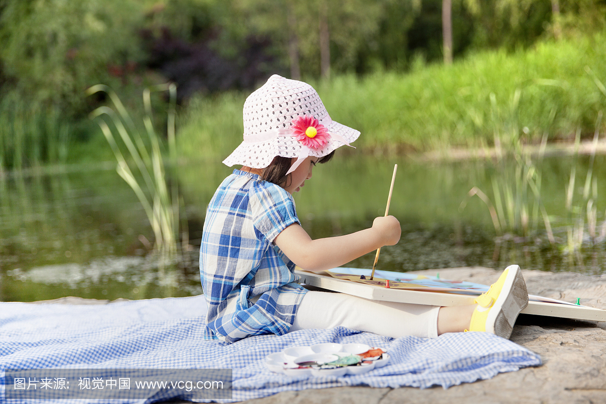 正在河边画画的小女孩
