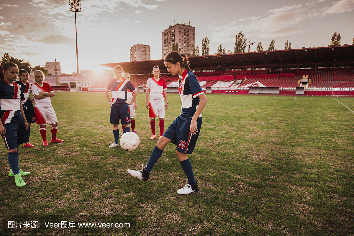 少年足球运动员练习与运动场上的球。