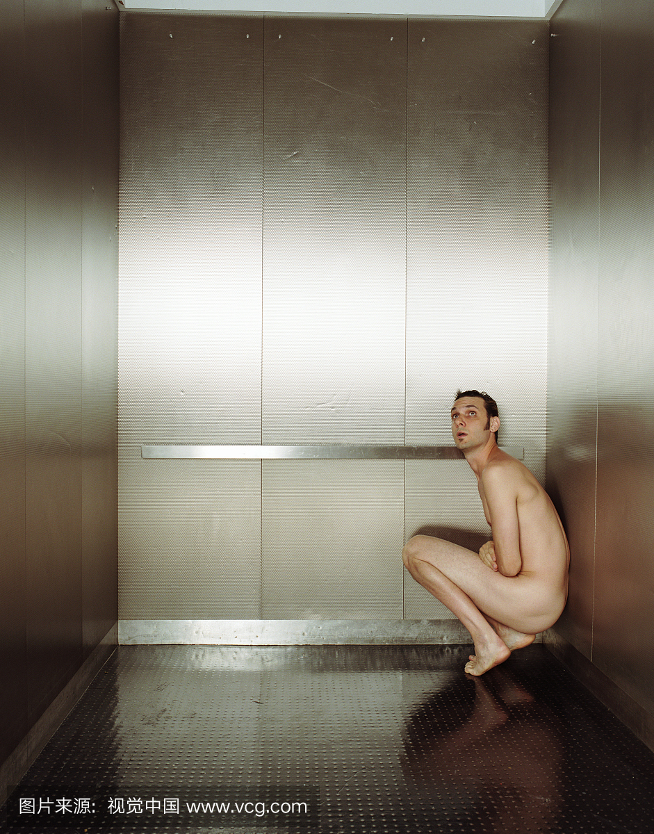 男人没有穿任何衣服,跪在电梯的角落