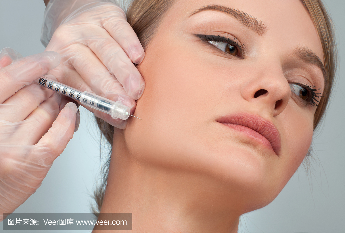 女人在脸颊上注射填充物。抗衰老治疗和瘦脸。