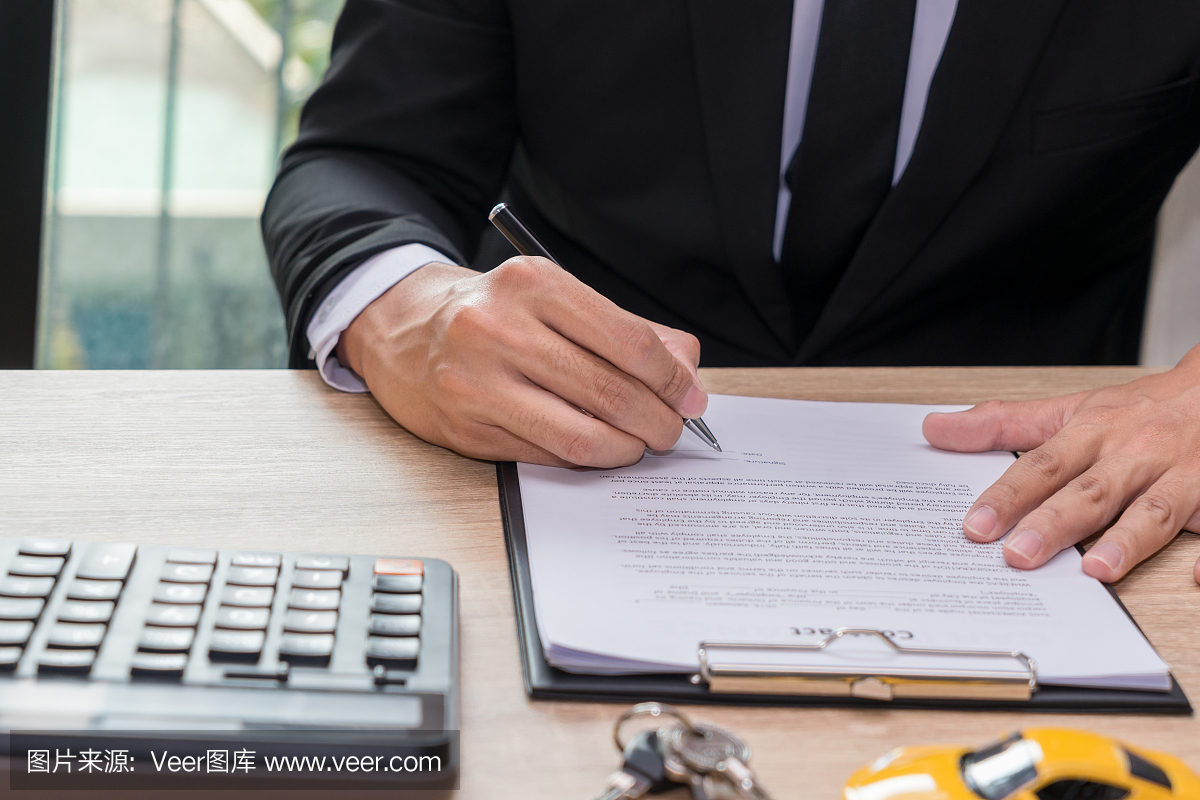 商人签署汽车贷款协议合同与汽车钥匙和计算器