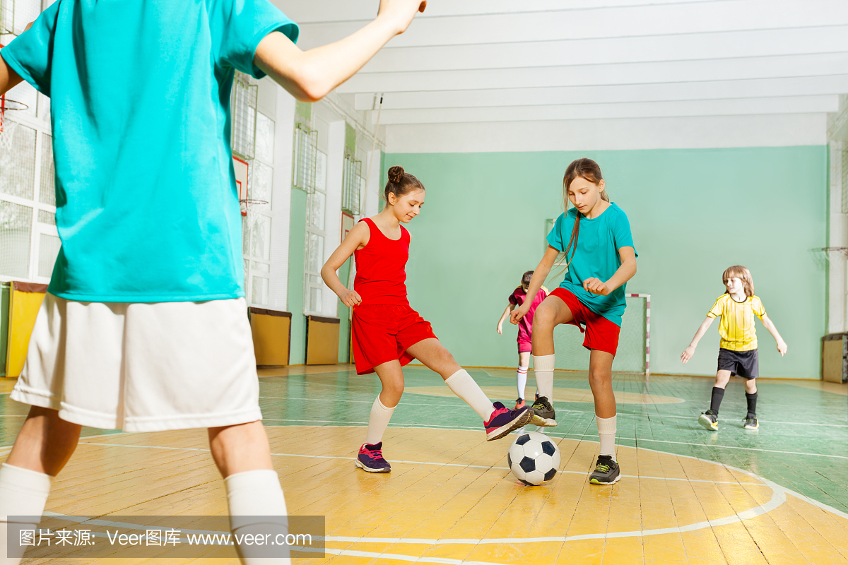 儿童训练足球在学校体育馆
