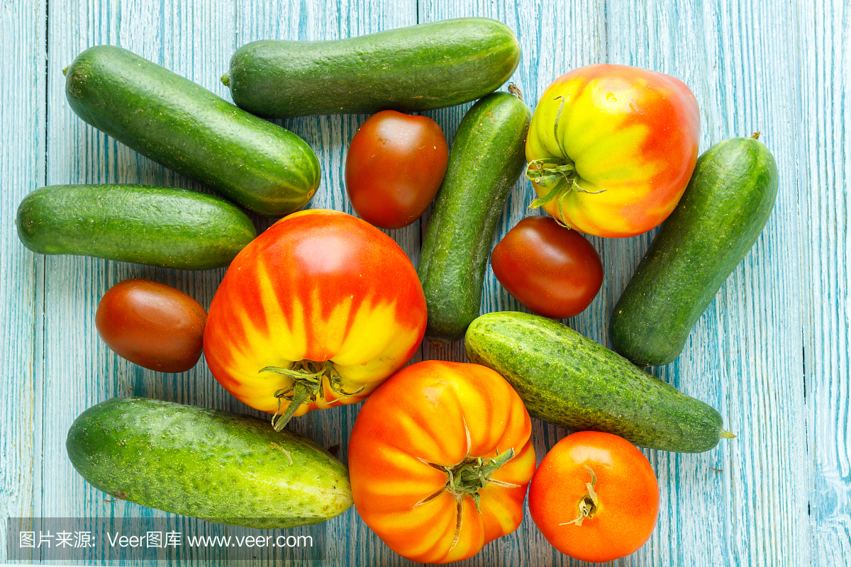 成熟的生蕃茄和黄瓜在木背景上