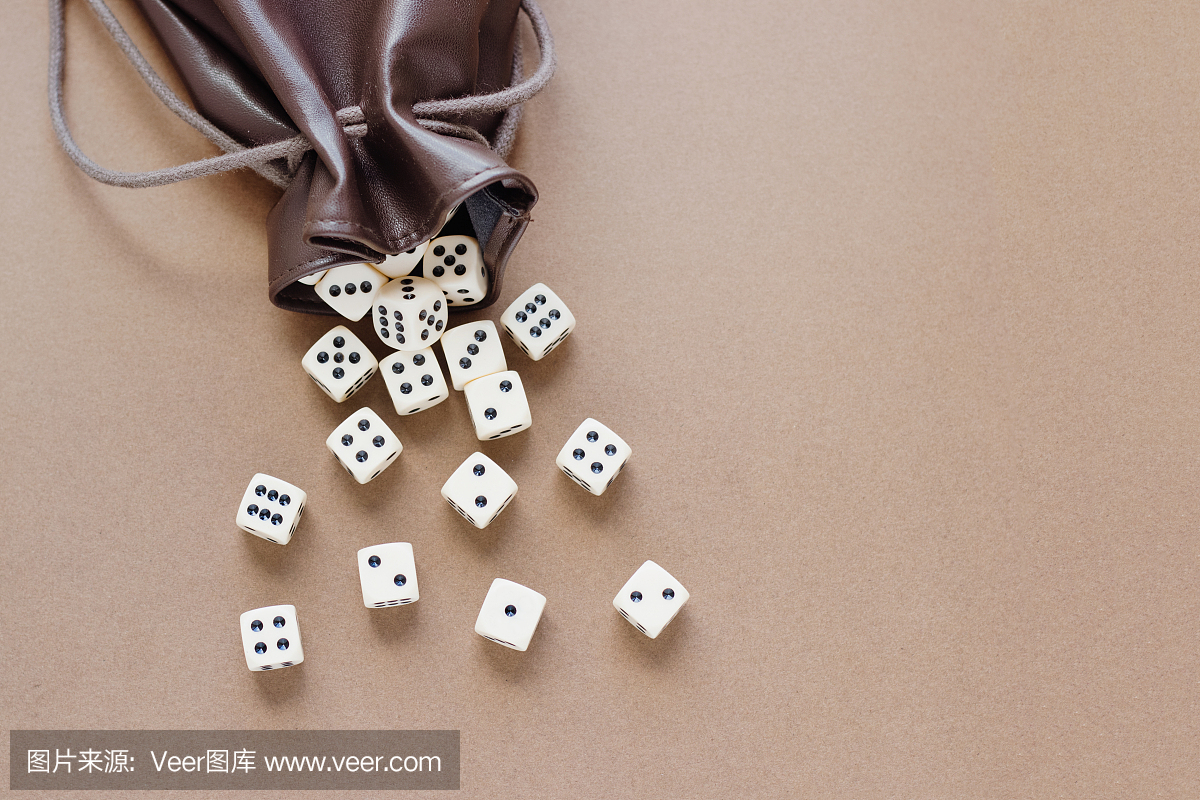 一套白色的游戏骰子棕色背景上的皮包展开。