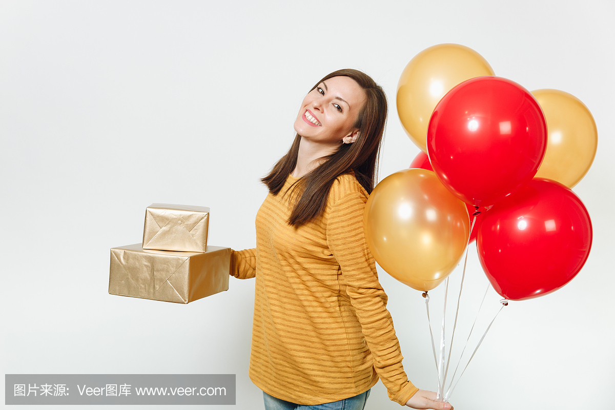 轻幸福的女人,穿着黄色的衣服,拿着生日红色气