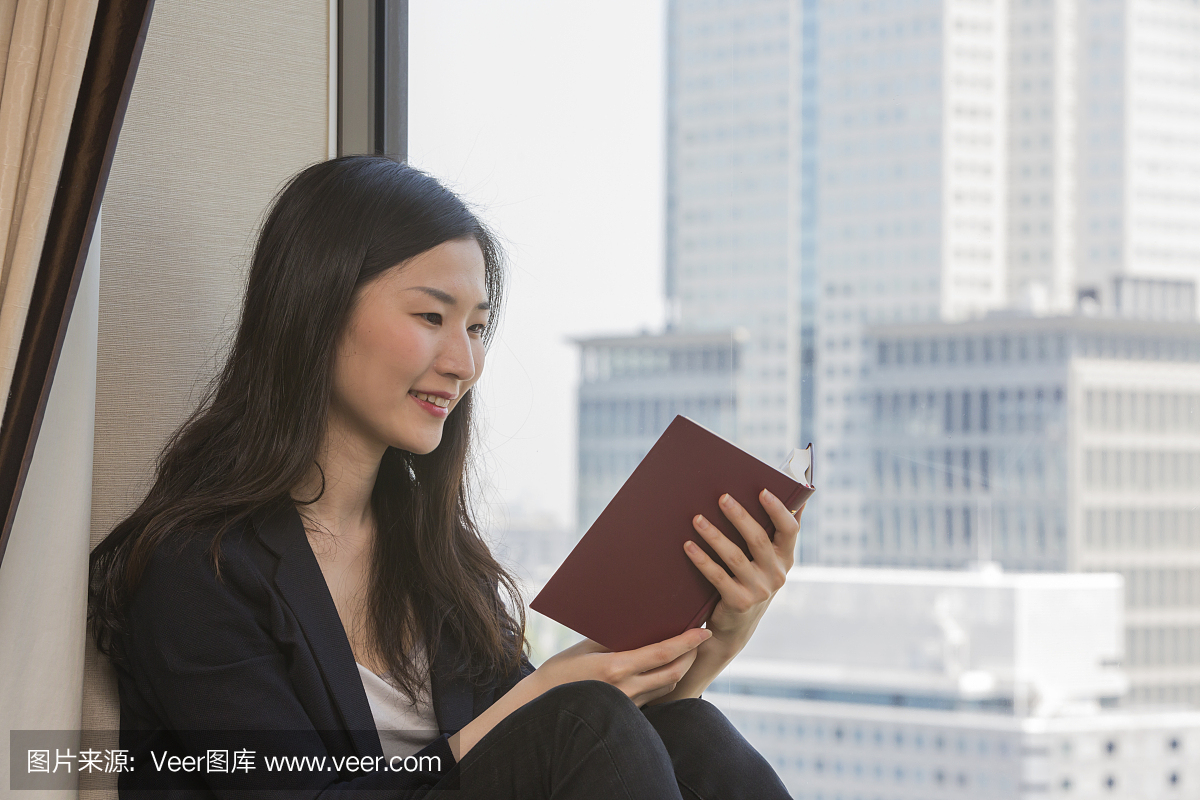年轻的现代日本女子坐在读一本书