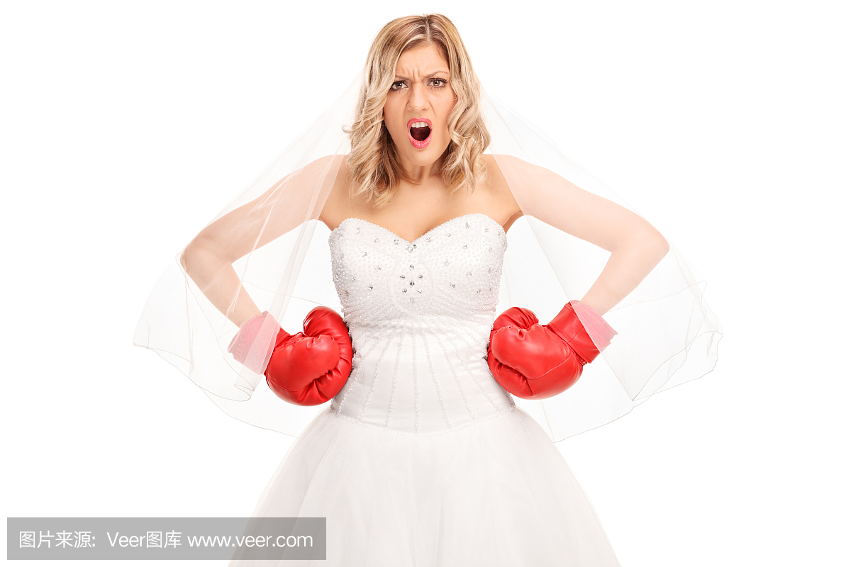 愤怒的新娘在婚礼礼服和拳击手套