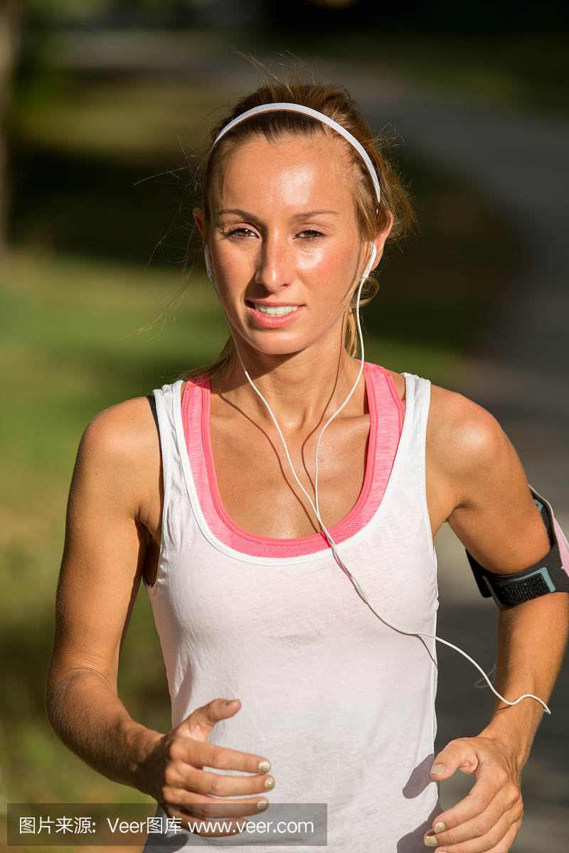 女人跑步听音乐从智能手机mp3播放器。