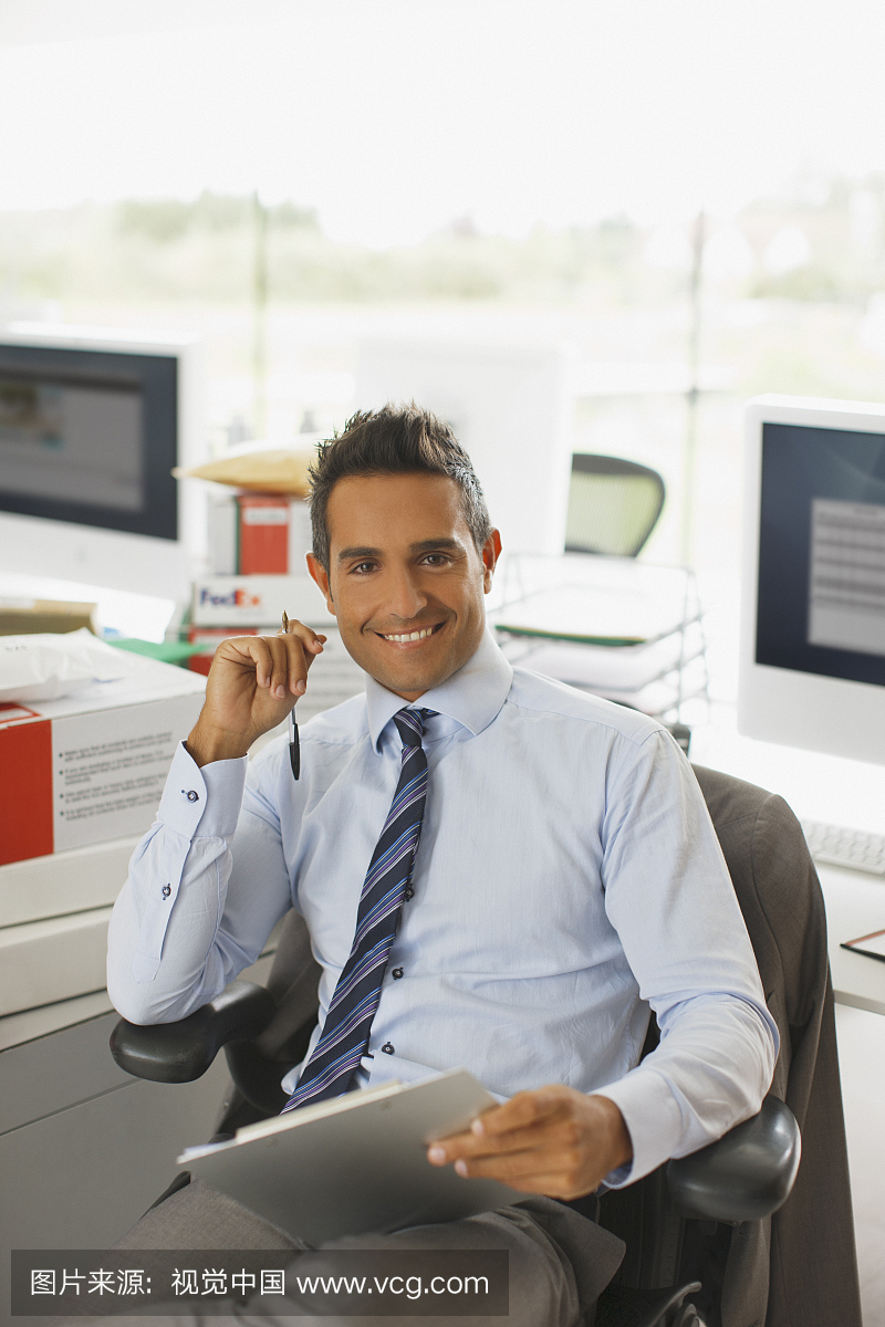 坐在桌子上的商人拿着剪贴板