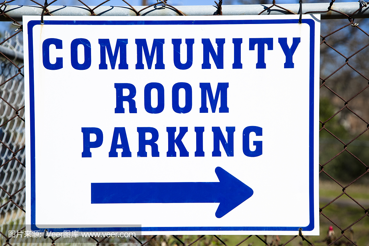 社区房间停车标志与箭头在围栏。户外。