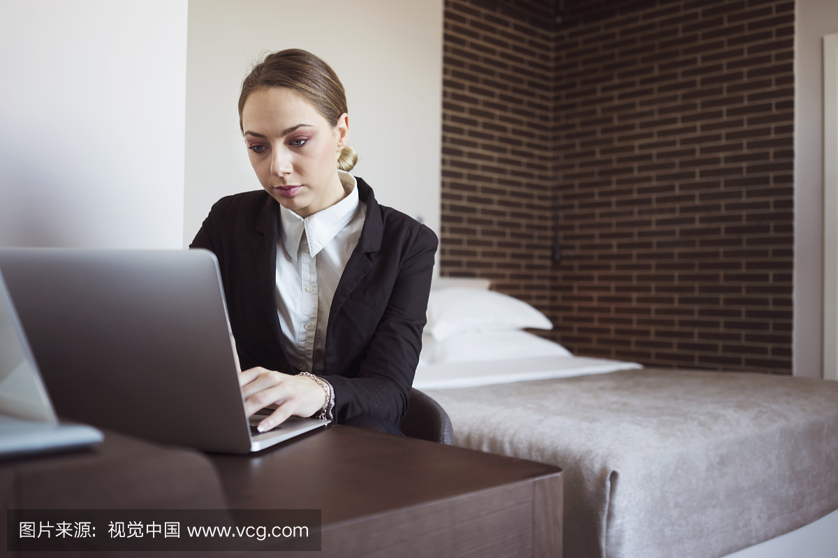 出差在酒店房间里工作的女商人