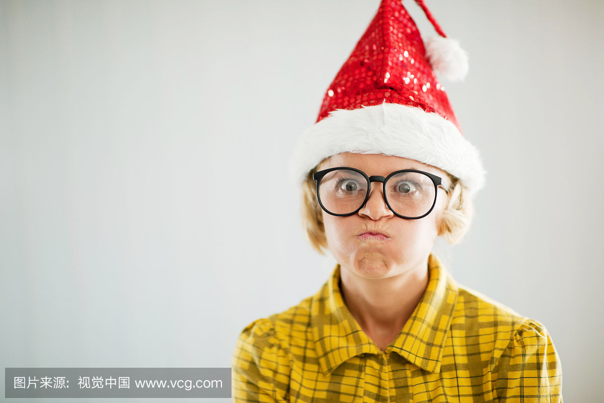 沮丧的有趣的女人戴着圣诞帽子。