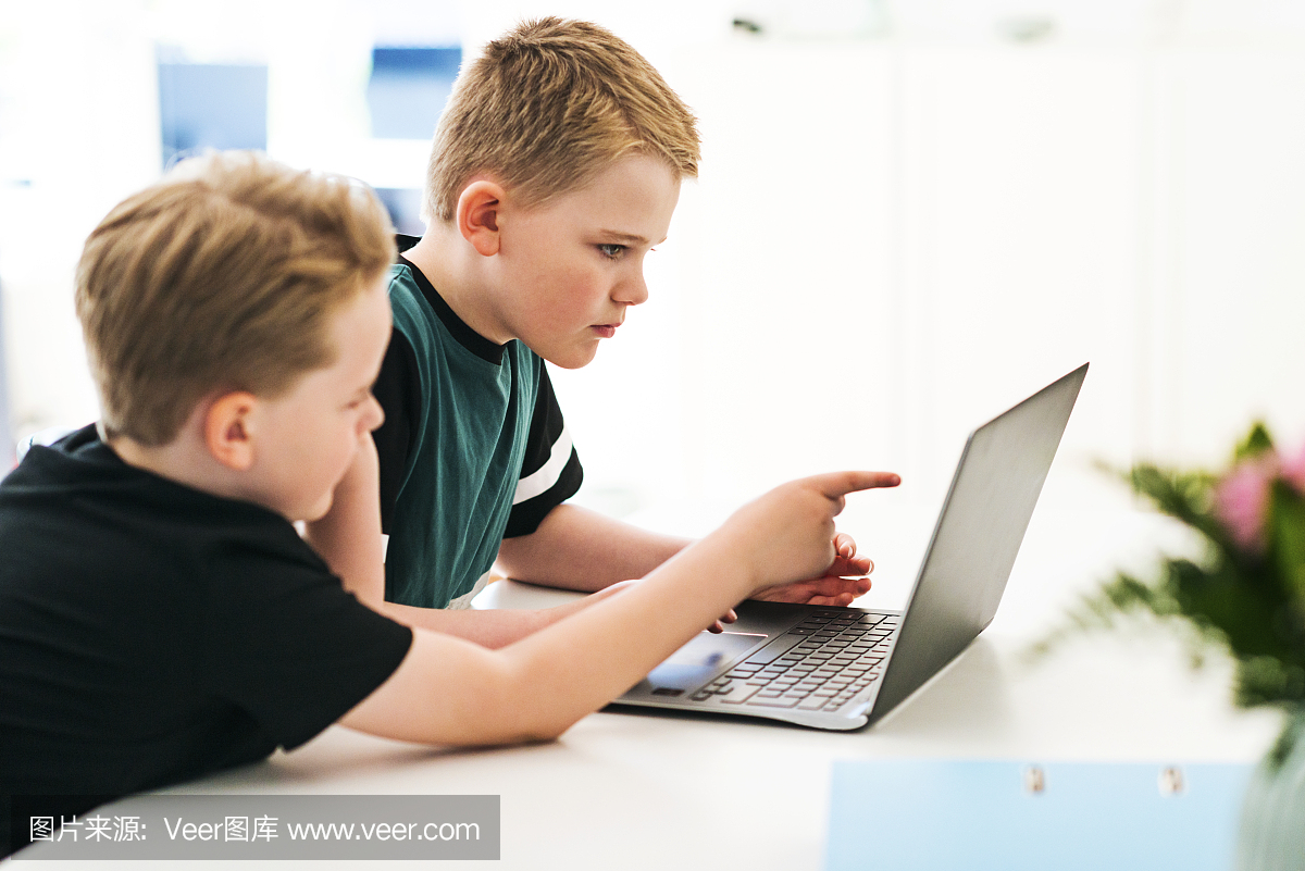 孩子互相帮助学习如何在笔记本电脑上编码