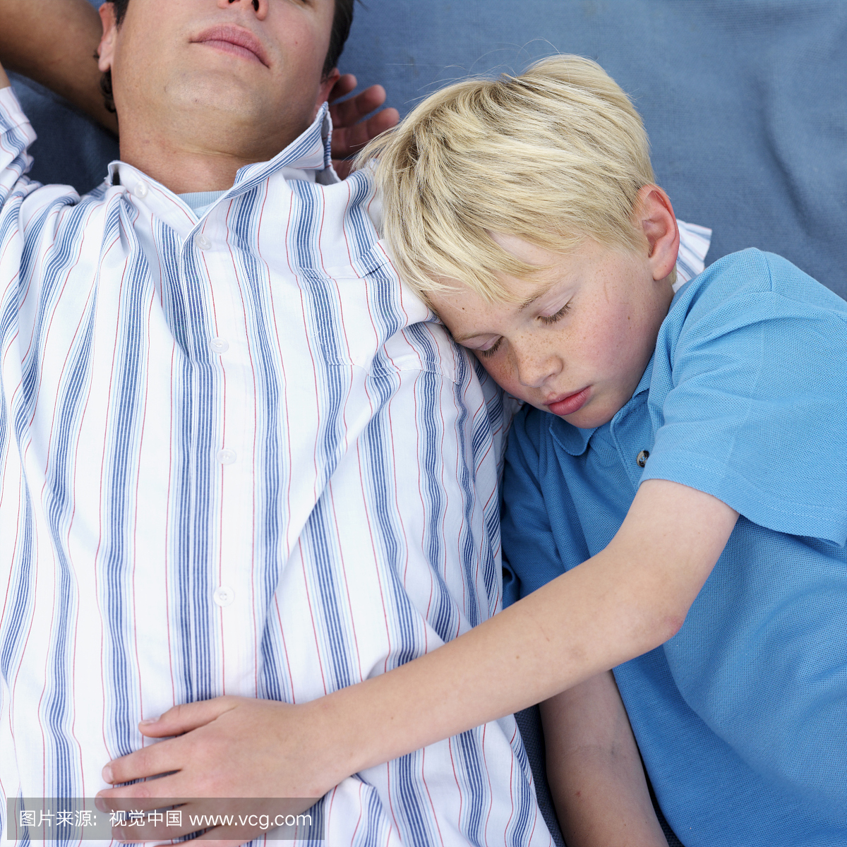 父亲和儿子(11-13)睡在户外,高角度视图,上半身