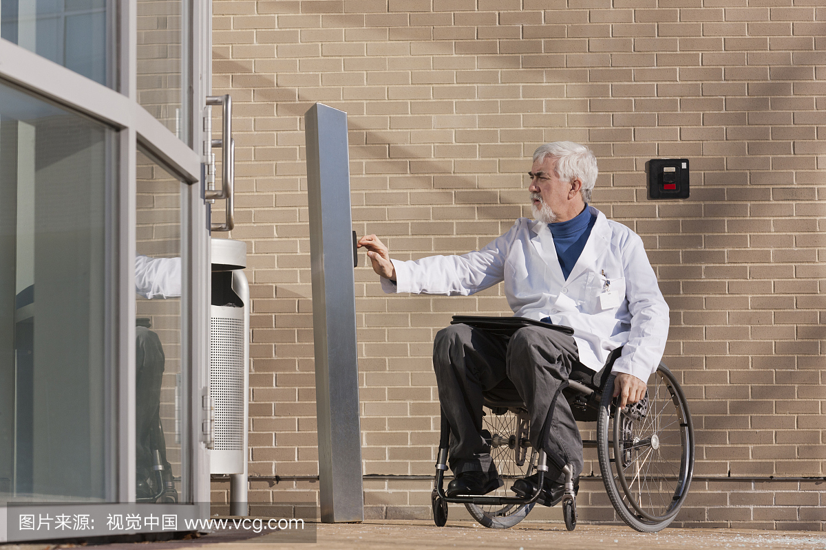 医生在轮椅上的肌营养不良症在医院门口按压旋