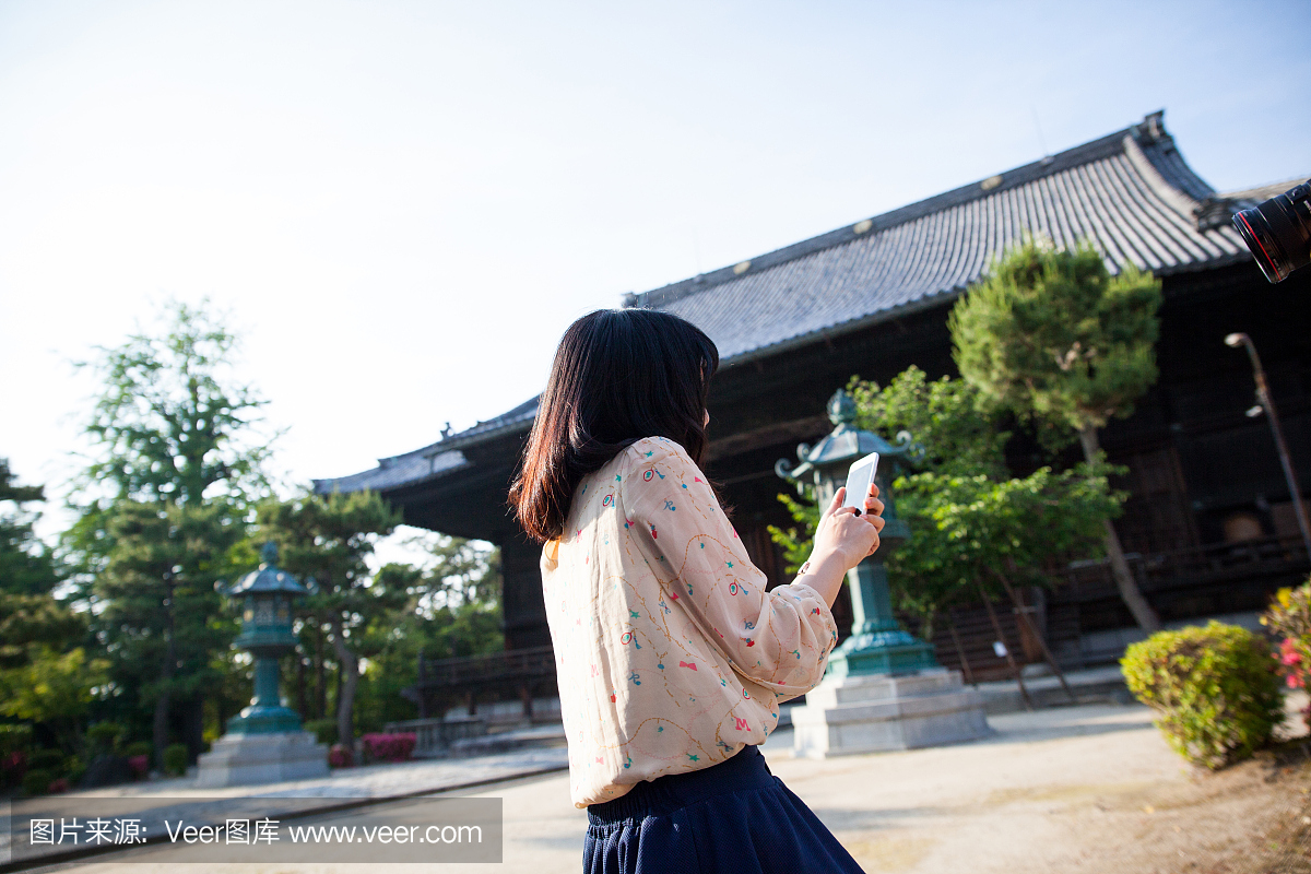 年轻的日本女性旅游使用她的手机