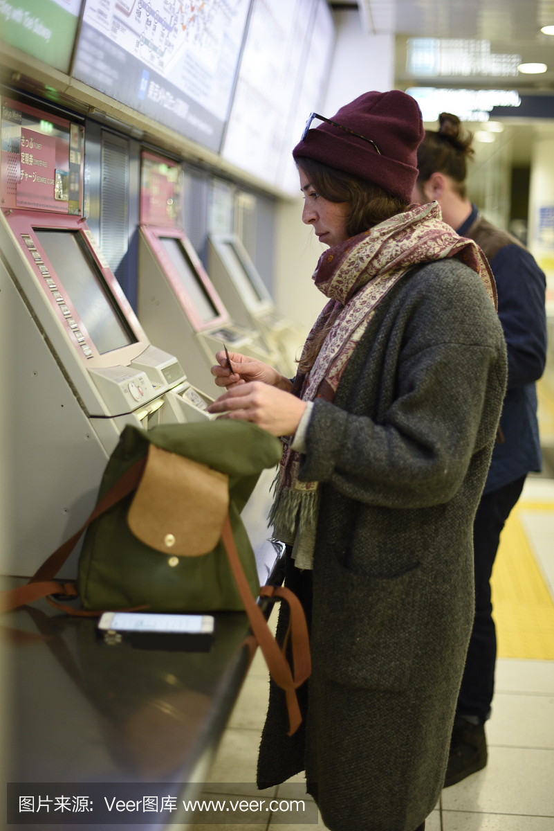 年轻女子在地铁站,东京,日本买票