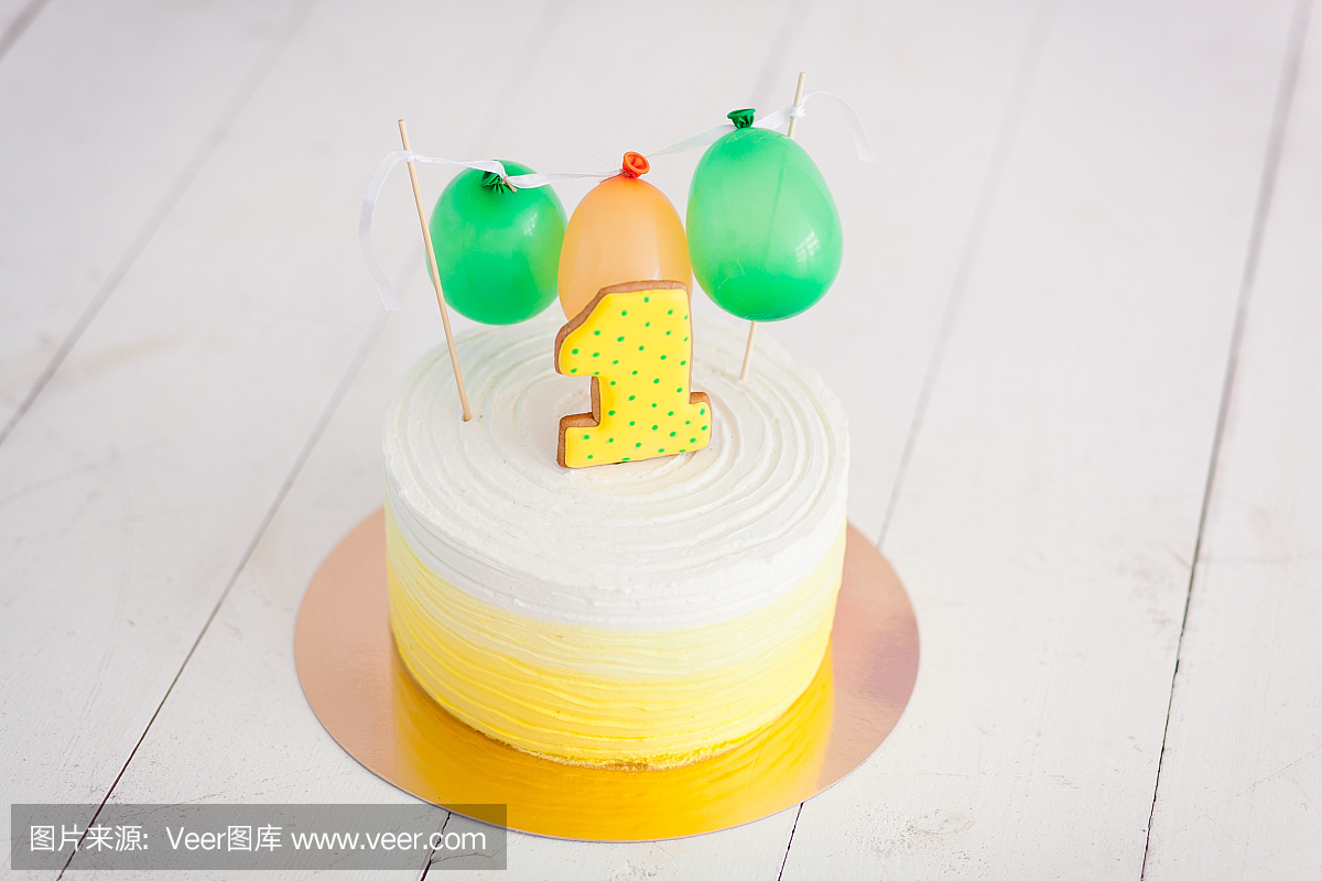 第一个生日粉碎蛋糕。蛋糕与第一和小气球。生