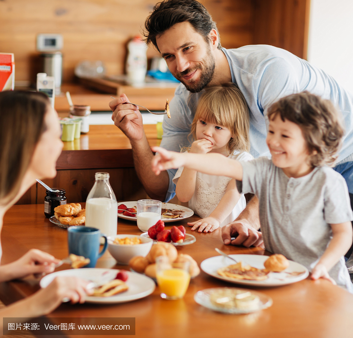 一个年轻幸福的家庭的早餐的照片