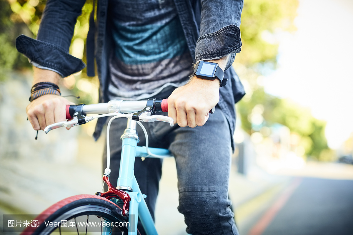 骑自行车时穿着智能手表的男人