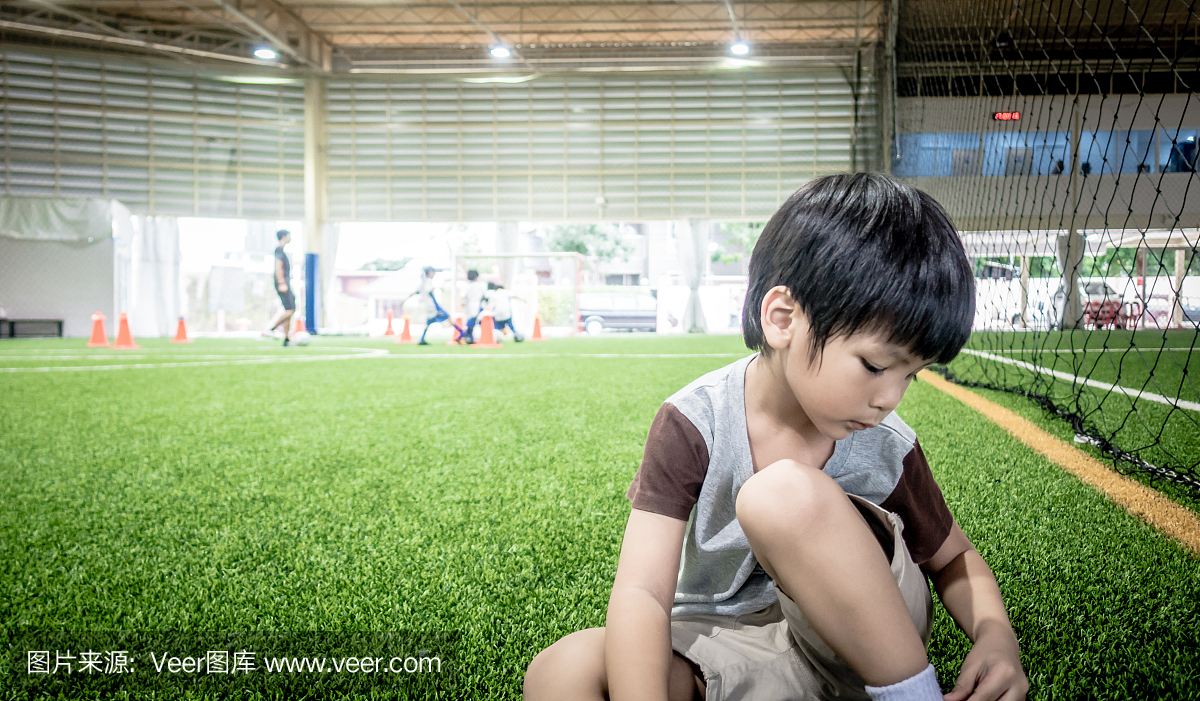 四岁的男孩正在与模糊副本空间的足球训练场上