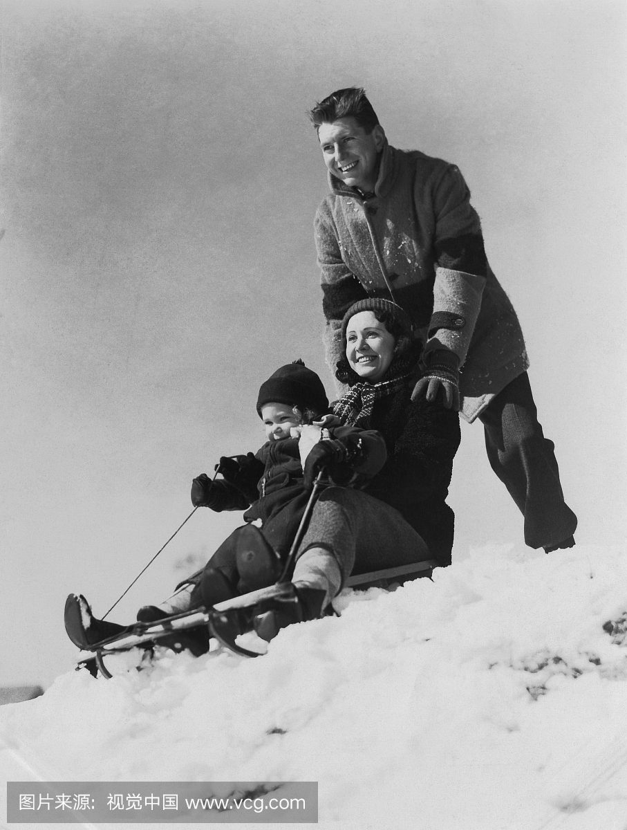 家庭在冬天一起乘坐雪橇