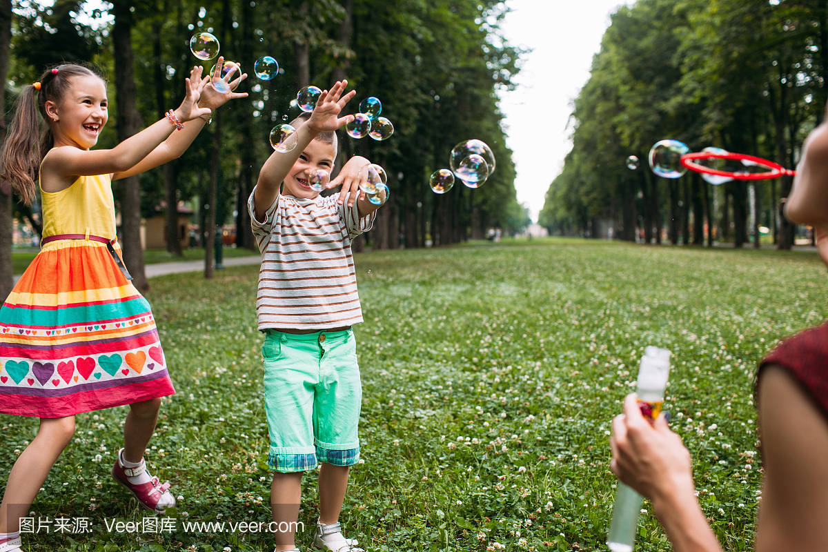 快乐的孩子们吹泡泡公园概念。