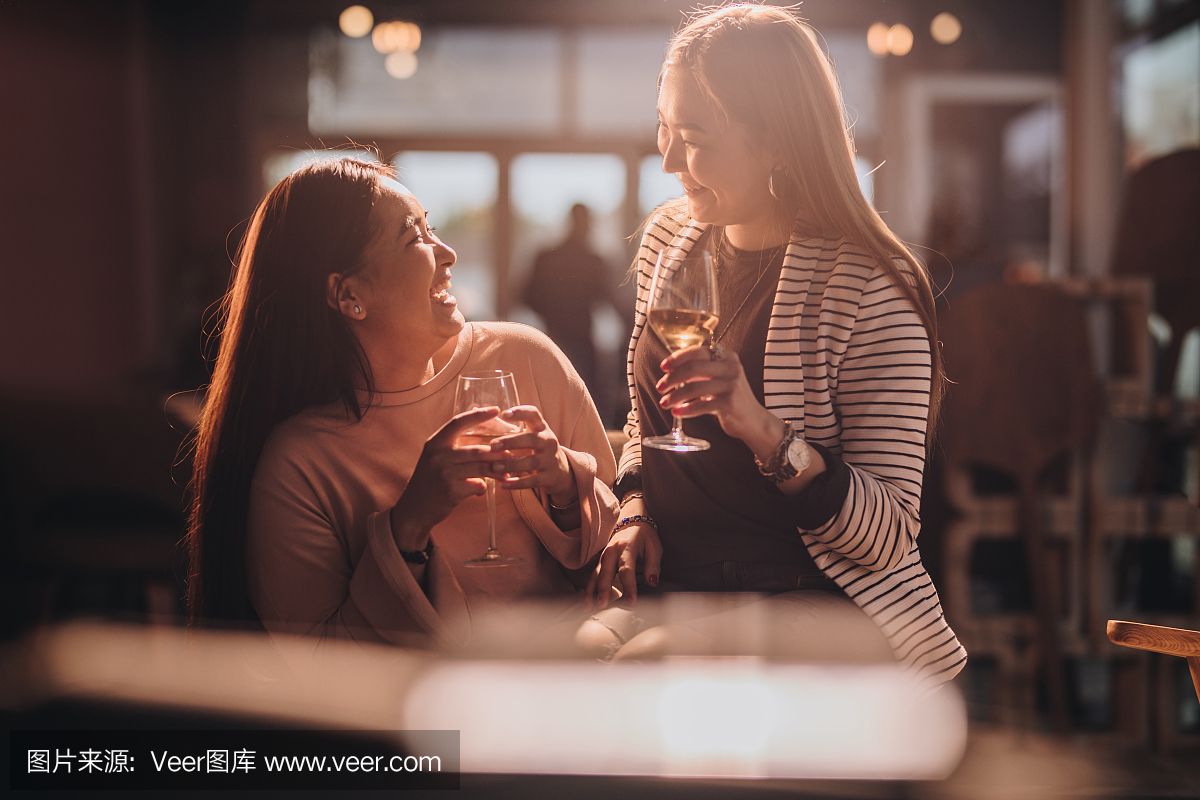 性格开朗的韩国女性在夜间在酒吧聊天。