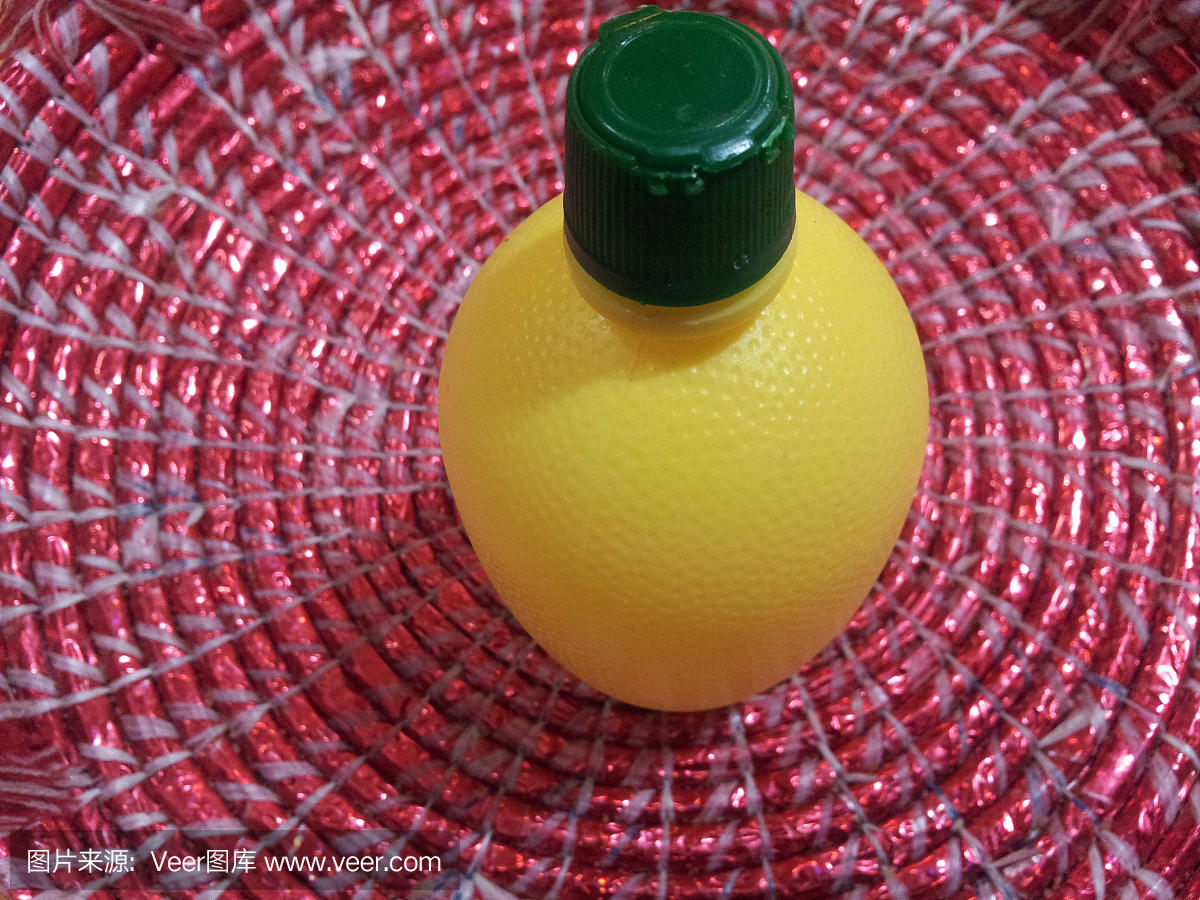 黄色柠檬汁瓶或容器与绿色的帽子