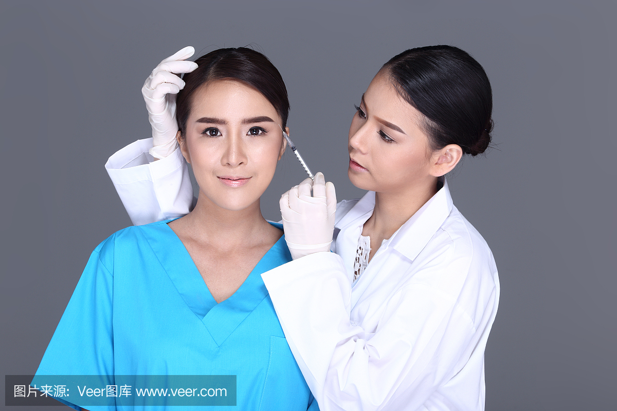 美容师医生在整形手术前将注射器放在面部结构
