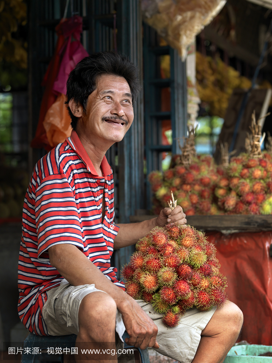 一个带红毛丹的微笑水果供应商。