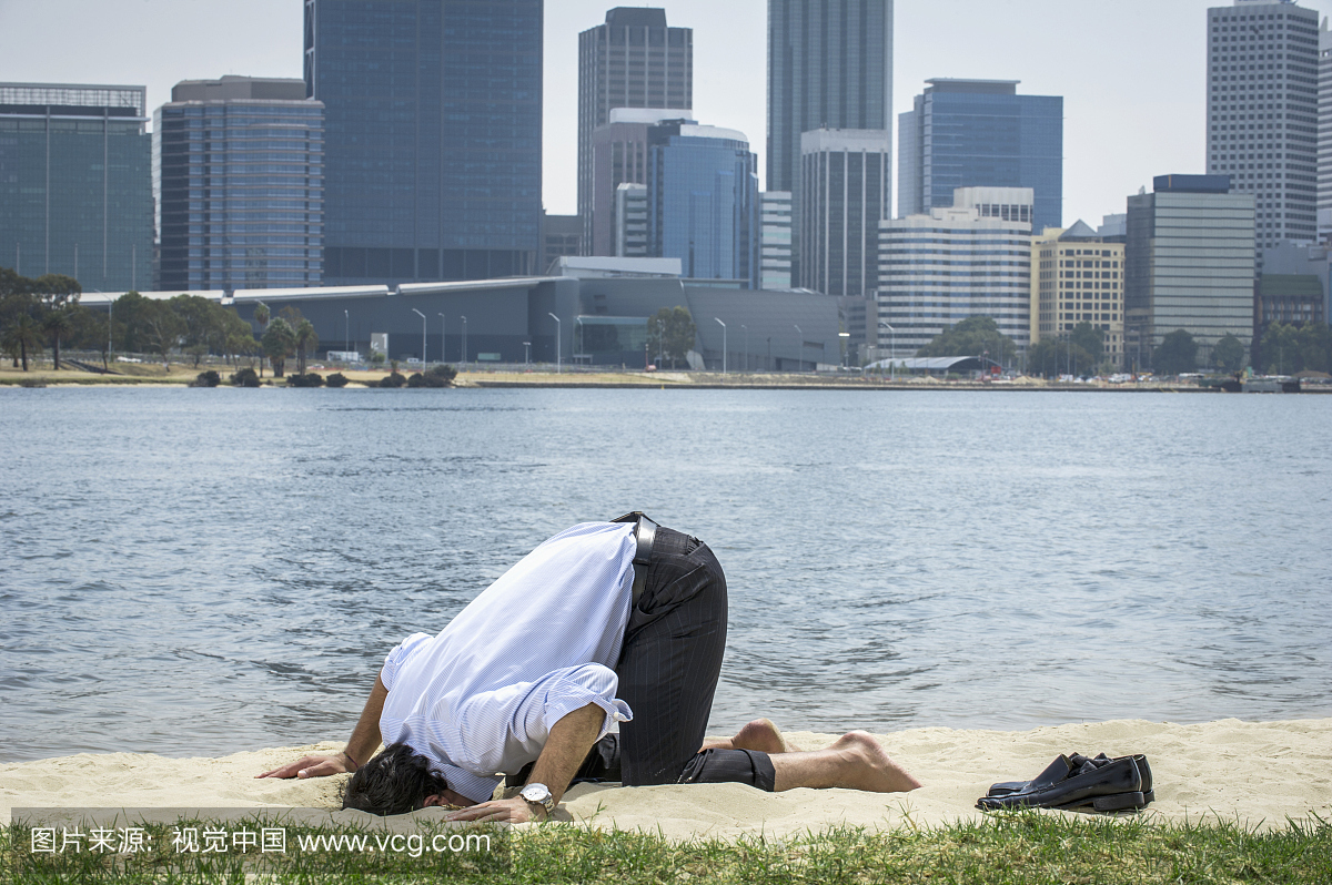 西班牙裔的商人将他的头埋在沙滩上,珀斯,西澳