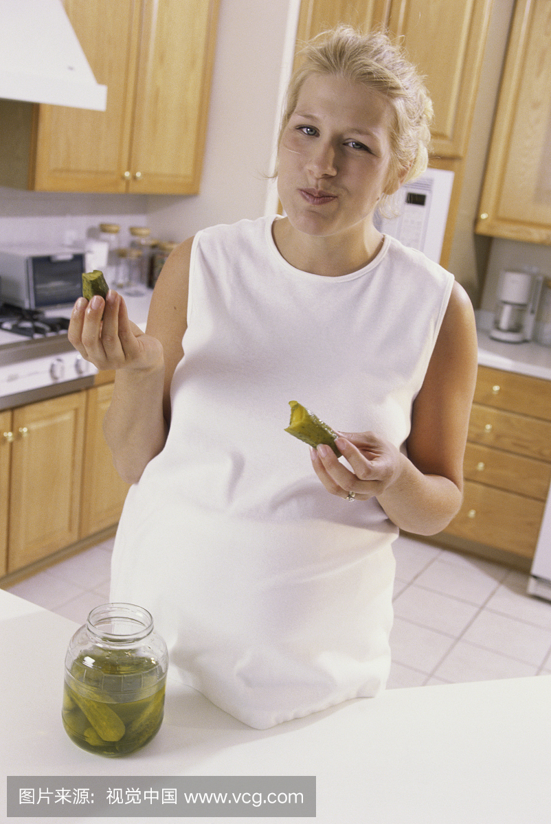 怀孕的女人吃泡菜的肖像