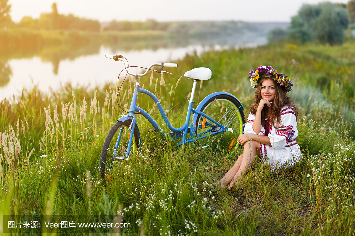 国家乌克兰民族服装与自行车的年轻女子