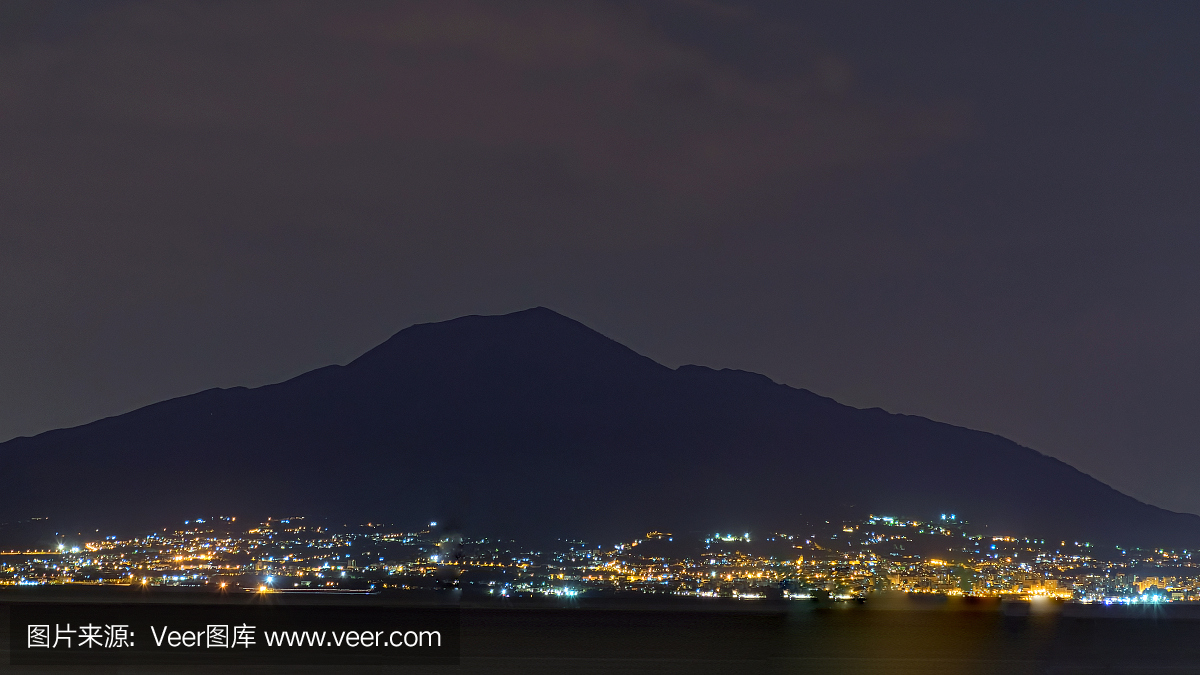 那不勒斯市的夜景在火山维苏威火山的背景中