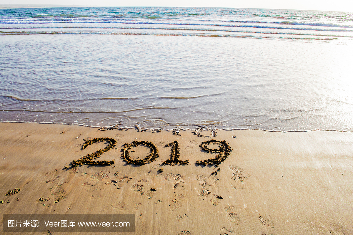 新年快乐2019海滩上的文字。即将到来的新年