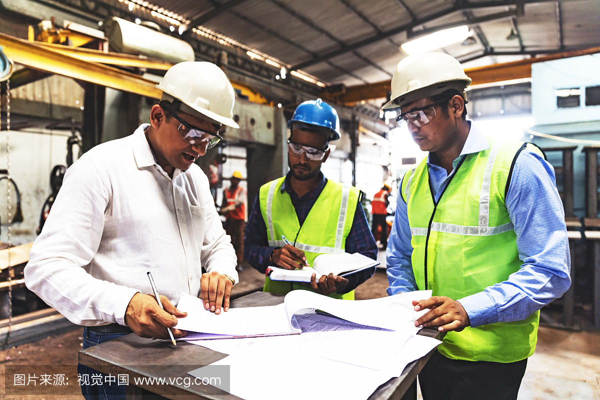 Factory owner reviewing documents for plans to