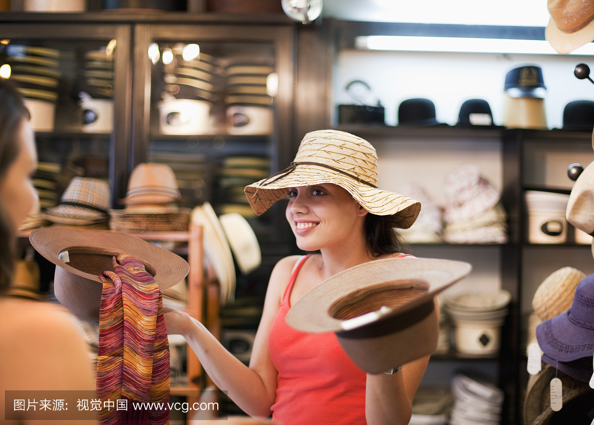 克罗地亚,萨格勒布,年轻妇女尝试帽子商店的帽