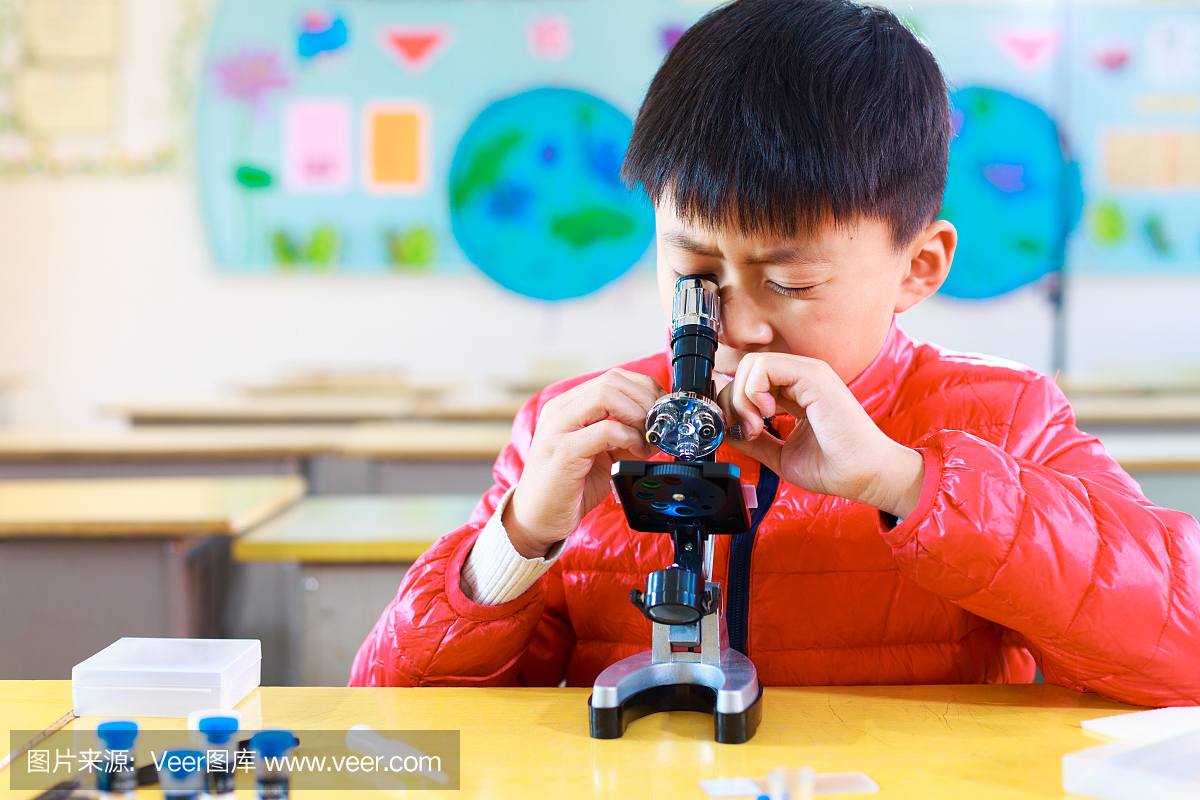 亚洲小学生在课堂上用显微镜进行实验