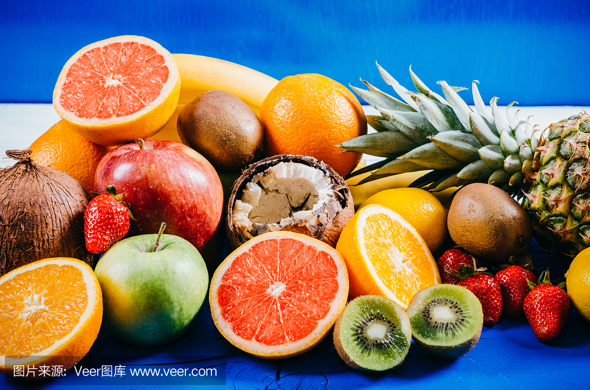 在蓝色木板上的热带和柑橘类水果的选择