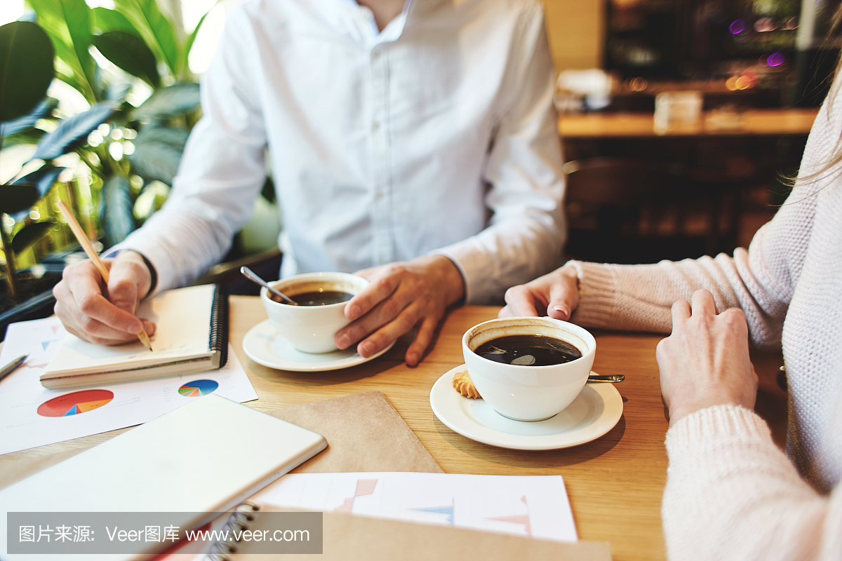 无法识别的商业人士在与论文工作时和在咖啡馆